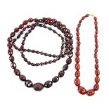 A graduated Bakelite necklace, length 42 cm and an opera length clear red faceted bead necklace,