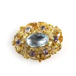 Regency floral brooch, set with foil backed central oval cut aquamarine and six round cut amethyst