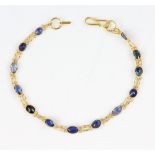 Sapphire bracelet; oval faceted blue sapphires spectacle set, 15cm length, mounted in 14 ct .