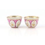 A pair of early 19th century Meissen teabowls, pink ground with gilt swags and floral decoration,