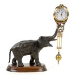 19th century style novelty pendulum clock in the form of an elephant on a wooden base 28cm . .