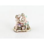 Meissen porcelain figural group depicting two putti, one holding aloft an ink well and the other