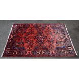 Persian red ground rug, with multiple borders, the centre with repeating foliate forms, 237cm x