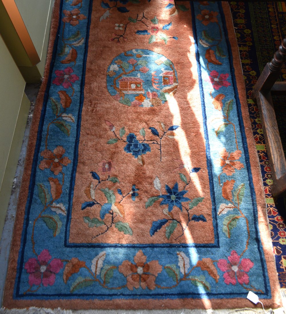 Chinese Orange ground rug with main blue border, the centre with cartouche and floral forms 188cm