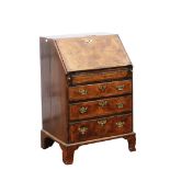 George II walnut bureau, fall flap enclosing well, cupboards, drawers and pigeon holes, over three