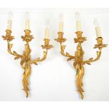 Pair of gilt metal three branch wall lights of foliate form, each 35 cm wide. .