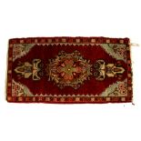 Persian red ground rug with multiple medallions and borders, and a small rug with a central