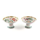 A pair of famille rose stem dishes; each one decorated on the top with a dragon and a phoenix (