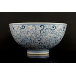 A blue and white bowl, decorated on the exterior with formal floral designs, the base with