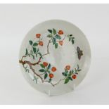 A famille rose dish of circular form, decorated with a butterfly flying above lychees in fruit;