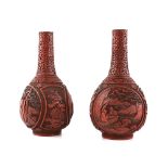 A pair of red cinnabar lacquer vases; each one with cylindrical neck, and decorated with panels of