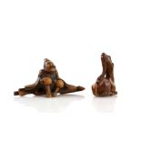 Two wood netsuke, comprising: a seated traveller wearing waraji, 7 cm long; and a seated kirin