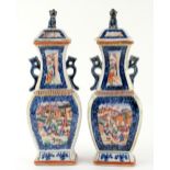 A pair of Chinese Export vases; each one with a domed cover and mythological animal finial; both