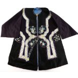 A Chinese or other Asian textile tunic with blue silk interior lining; decorated with floral bands