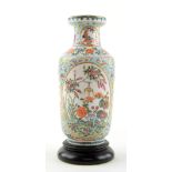 A small famille rose vase of rouleau form, decorated with oval panels of floral designs; the base