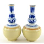 A pair of underglaze blue and pale monochrome decorated vases, each one about 16 cm high, post