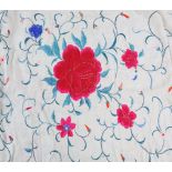 A Chinese textile shawl, decorated with bold red flower heads and scrolling linear motifs on an