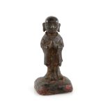 A small Chinese metal figure of a standing Luohan, standing with both hands clasped together in