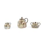 A Chinese, or other Asian, hammered white metal teapot, sugar bowl, and cream jug; each one