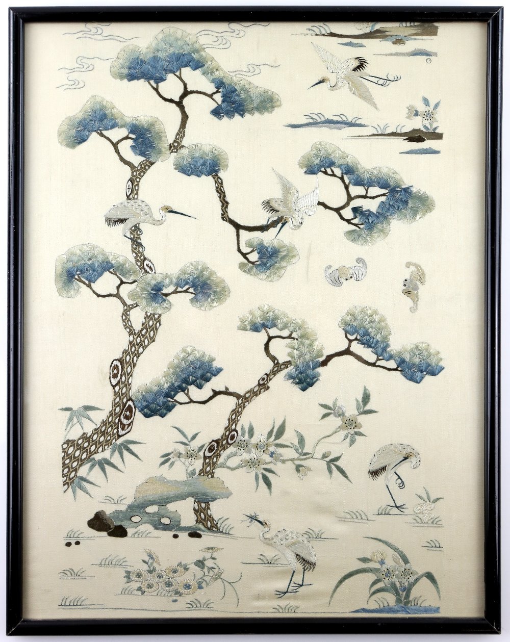 A Chinese silk panel embroidered with The Daoist theme of Cranes, flying through pine trees,