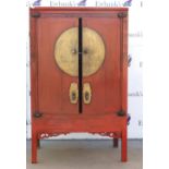 A Chinese scarlet lacquered cabinet with central, circular fitting across the hinged doors; 107 x 61