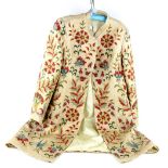 An Indian embroidered coat with extensive floral embroidery worked in chain stitch, beige silk