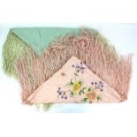 A 1920s silk shawl with deep fringe in peach embroidered with flowers, together with a similar in