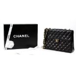 A Chanel Jumbo quilted black lambs skin single flap handbag and leather shoulder strap, exterior