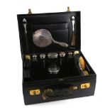 A leather vanity/ dressing case with silver hand mirror, 5 silver covered glass toilet bottles, pair