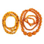 Three bead necklaces, one long necklace, testing as an Amber and resin composite, with oval beads