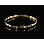 Oval gold bangle, set with round brilliant cut diamond, estimated weight 0.06 carats, mounted in 9