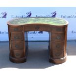 Early 20th century mahogany kidney shaped desk, with one long and eight short drawers on a plinth