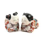 Pair of Chinese figures of crouching children approx. 25 cm long .