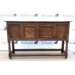 18th century style oak dresser base, carved frieze and panels and having two cupboard doors, on