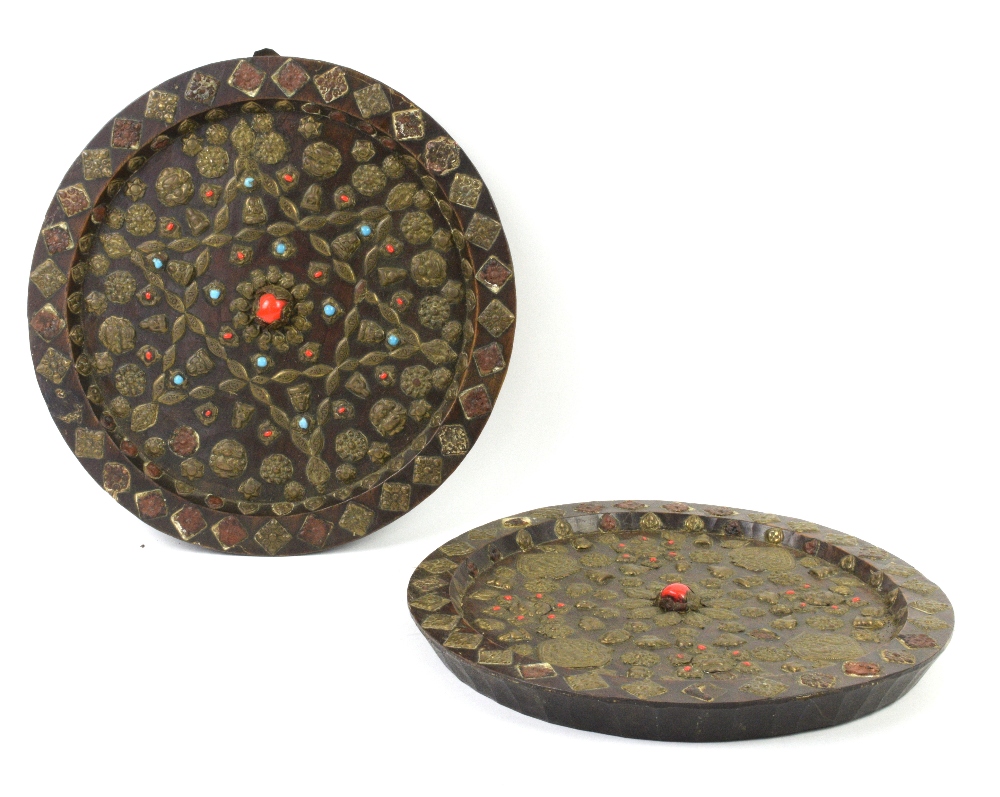 Pair of Tibetan circular wooden plaques the metal work set with coloured stones 36cm dia.