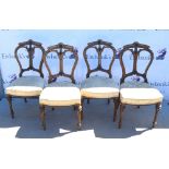 Four Victorian walnut dining chairs, floral upholstered seats on tapering reeded legs.