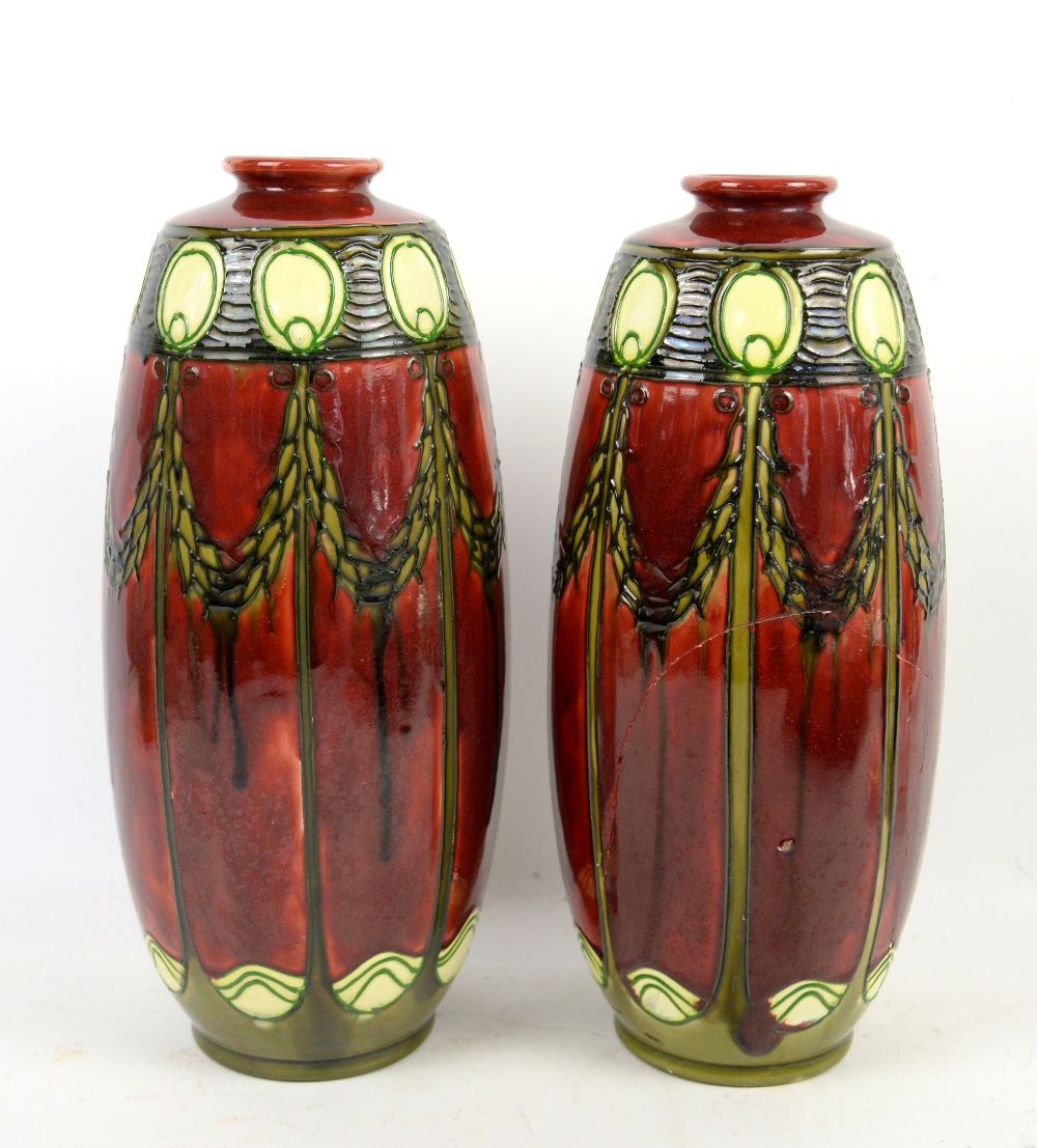 A pair of Minton Secessionist vases No. 1 circa 1910 in red with tube lined swags in green (