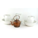 Two large white porcelain jugs, another ewer, two basins and a copper kettle.