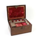 Wooden dressing table box with red velvet interior, containing glass bottles highlighted in gilt,