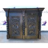 20th century oak cabinet, two cupboard doors carved with flowers and busts, having barley twist
