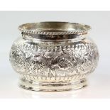 White metal bowl, the body decorated with scrolling flowers and leaves on a stippled ground, stamped