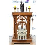 Wooden altarpiece with Corinthian columns and pierced crucifix, surrounded with candlesticks,