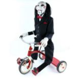 Saw - Billy the Puppet, life-size model on tricycle. With large display case. Provenance: