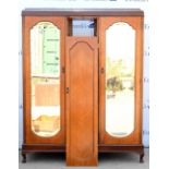 Early 20th century wardrobe, with central cupboard door revealing shelves flanked by two doors