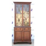 Early 20th century mahogany glazed bookcase, dentil cornice above astragal glazed door, two short