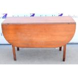 Mahogany drop leaf table, raised on reeded legs, 75 x 122cm