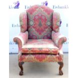 Mahogany wingback armchair, floral upholstery on ball and claw feet