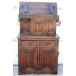 18th century style oak buffet, with hinged top above cupboard door with carved linenfold