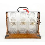 Three bottle oak tantalus with plated mounts and decanter labels Decanters with very minor chips and