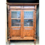 Indonesian hardwood cabinet with two drawers over doors on turned supports,